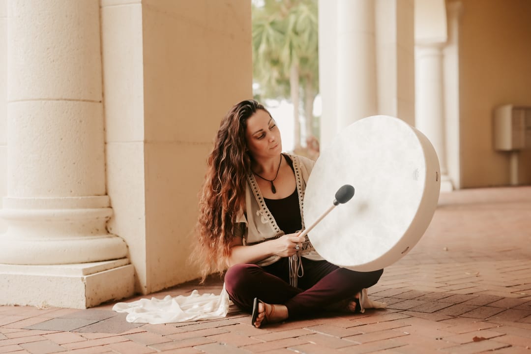 Krysta playing a frame drum during an energy work session